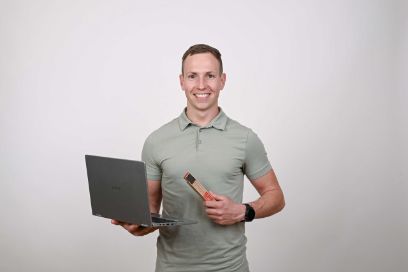 Jonas Held, stehend mit offenem Laptop in der einen und Doppelmeter in der anderen Hand