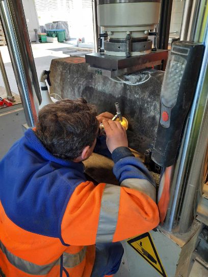 Projektbeispiel ReUseB91: Ein Mitglied des Forschungsteams sortiert und prüft gebrauchte Betonbahnschwellen.