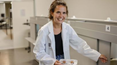 La responsable du laboratoire, Saskia Mantovani, tend les échantillons de compote de pommes à travers une petite porte à un membre du panel d’expert-e-s de la BFH-HAFL.