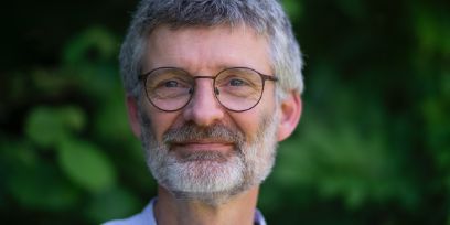 Portrait von Sebastian Dobruskin. Er ist in der Mitte des Bildes und blickt durch eine Brille freundlich in die Kamera. Der Mund ist geschlossen, die Gesichtszüge sind recht entspannt. Die graumellierten Haare trägt er kurz.