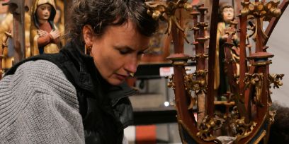 Nahaufnahme: Die dunkelhaarige Frau schaut bei der Arbeit konzentriert nach unten.