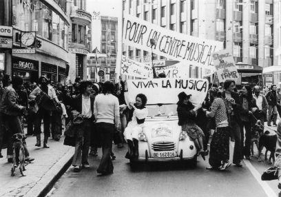 Schwarzweiss-Foto eines Demonstrationszuges mit Transparenten in den Siebzigerjahren in der Innenstadt von Genf.