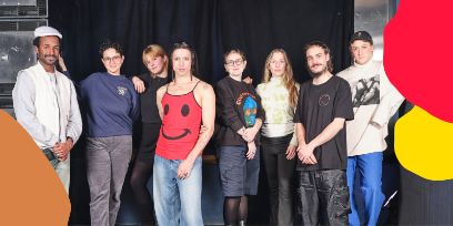 Junge Frauen und Männer stehen in einer Reihe vor einem schwarzen Vorhang.