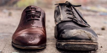 Ungleichheit symbolisiert mit einem ungleichen Paar Schuhe, einmal reich und einmal arm.