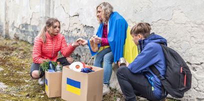 Ukrainische Familie nimmt Hilfspakete in Empfang.