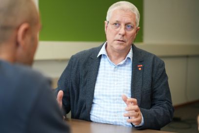 Porträt von Thomas Michel, im Gespräch mit Simon Steger. Er gestikuliert.