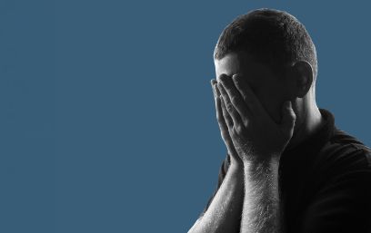 Ein Mann hält die Hände vor das Gesicht. 