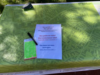 Ein Quartierplan, Fragen und farbige Punkten liegen bereit.