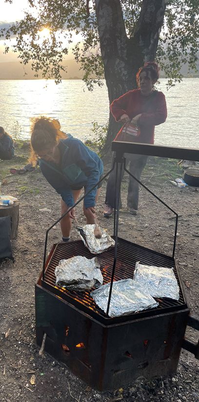 Die Studierende kochen auf dem Feuer.