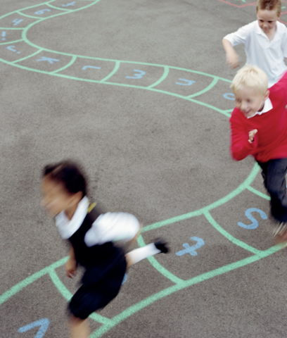 Kinder spielen auf dem Pausenplatz, am Boden sind Kreidespuren