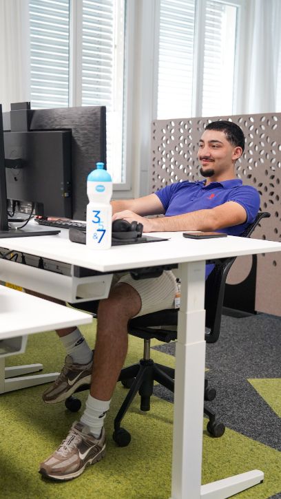 Rojan sitzt im Büro am Computer