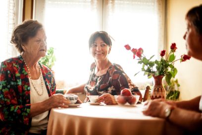 Seniorin, Tochter und Pflegerin beim Kaffeeplausch