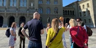 Mehrere Menschen stehen vor dem Bundeshaus.